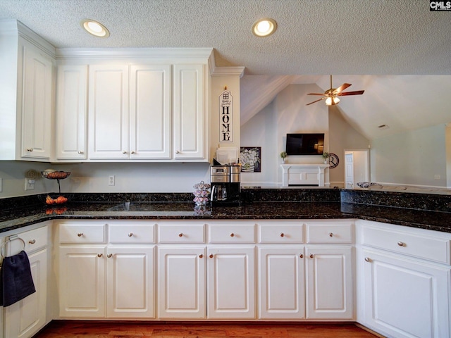 78 Southern Oak Dr, Camden, SC 29020 - kitchen with dark stone counters, a ceiling fan, a textured ceiling, lofted ceiling, and white cabinetry