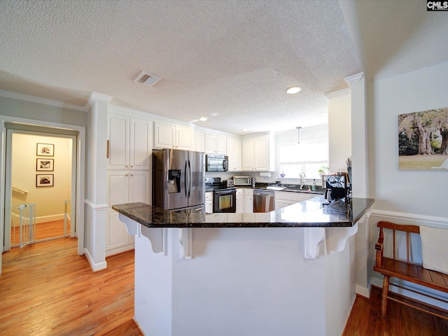 78 Southern Oak Dr, Camden, SC 29020 - kitchen with a textured ceiling, a sink, a breakfast bar area, stainless steel appliances, and ornamental molding