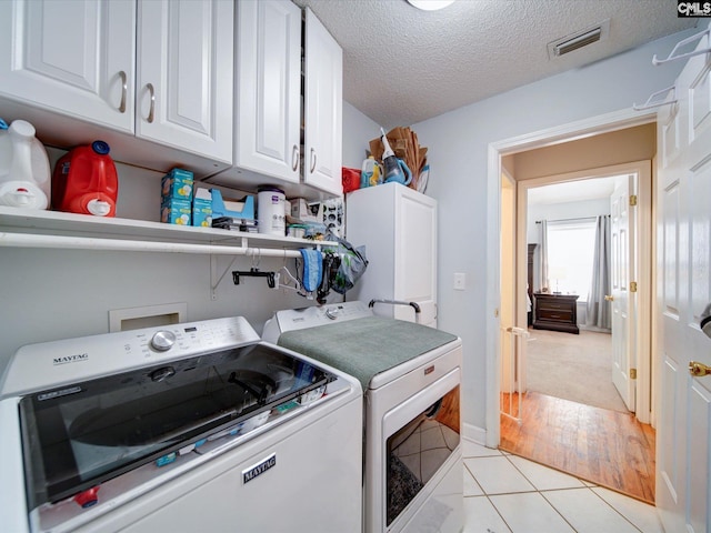 78 Southern Oak Dr, Camden, SC 29020 - washroom with a textured ceiling, washing machine and dryer, visible vents, cabinet space, and light tile patterned floors