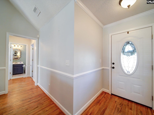 78 Southern Oak Dr, Camden, SC 29020 - foyer with light wood-style flooring, a textured ceiling, vaulted ceiling, visible vents, and baseboards