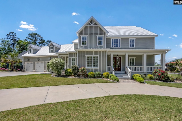 craftsman-style house with a front lawn, board and batten siding, driveway, a porch, and metal roof
