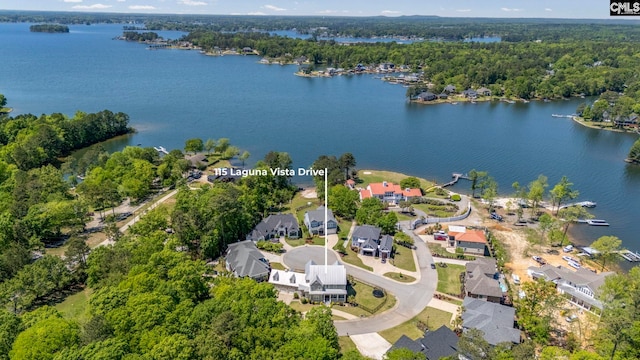 drone / aerial view featuring a residential view, a view of trees, and a water view