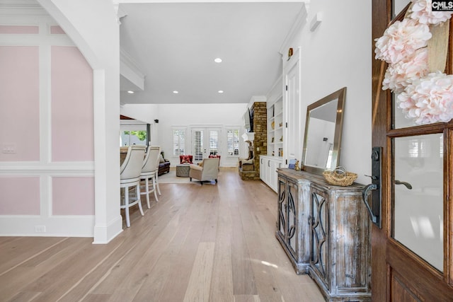 entryway featuring light wood-type flooring, recessed lighting, and crown molding