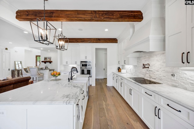 kitchen with premium range hood, white cabinets, black electric stovetop, and beam ceiling