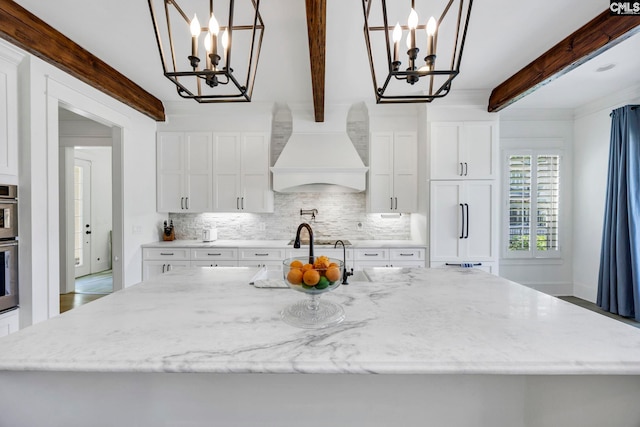 kitchen with premium range hood, decorative backsplash, and an inviting chandelier