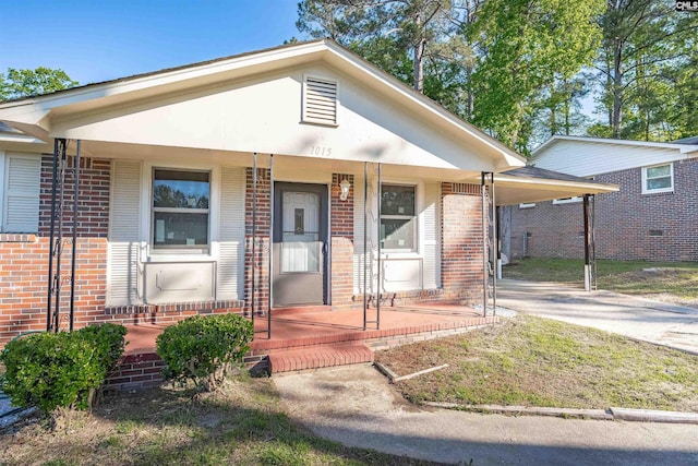 1015 Mandel Dr, Columbia, SC 29210 - bungalow-style house featuring a porch, brick siding, an attached carport, and concrete driveway
