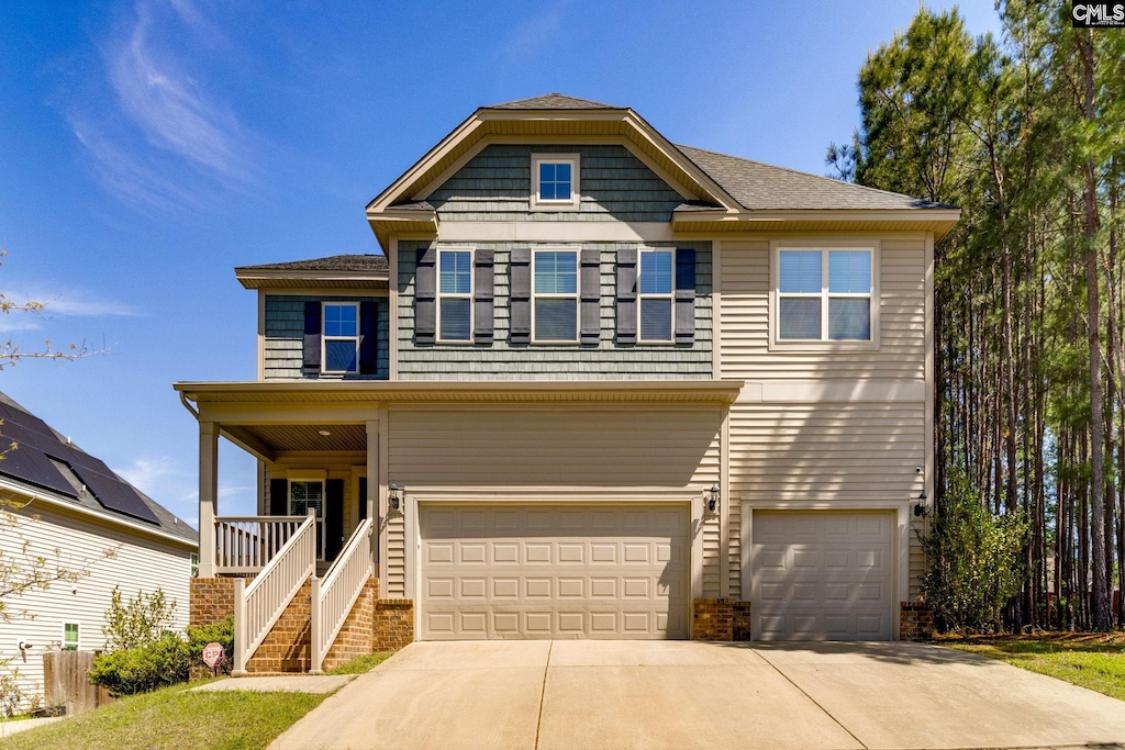 view of front of house featuring driveway, a porch, stairway, and a garage