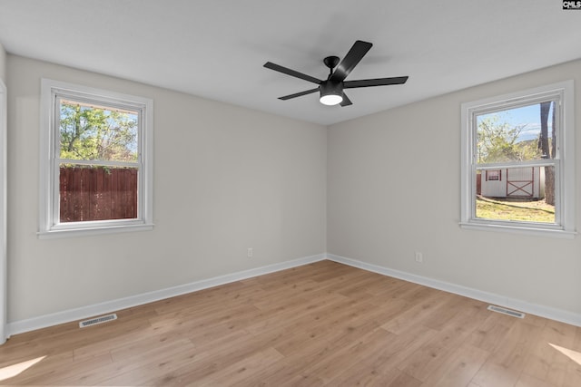 spare room with light wood-style flooring, visible vents, and a healthy amount of sunlight