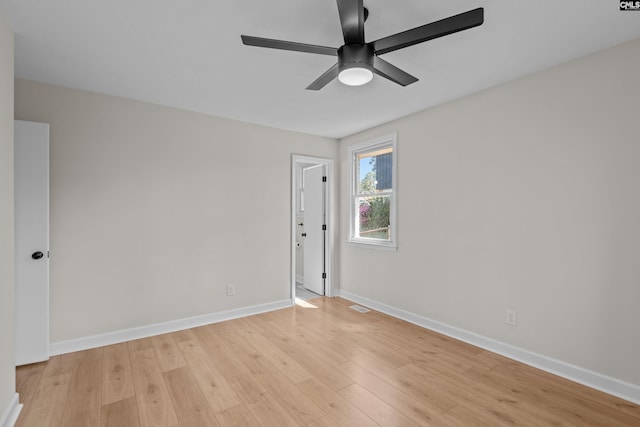 spare room featuring visible vents, a ceiling fan, baseboards, and light wood-style flooring
