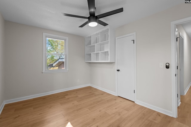 spare room with ceiling fan, baseboards, and light wood finished floors