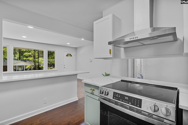 kitchen featuring white cabinets, stainless steel electric stove, dark wood finished floors, wall chimney exhaust hood, and recessed lighting