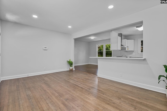 unfurnished living room featuring baseboards, wood finished floors, and recessed lighting