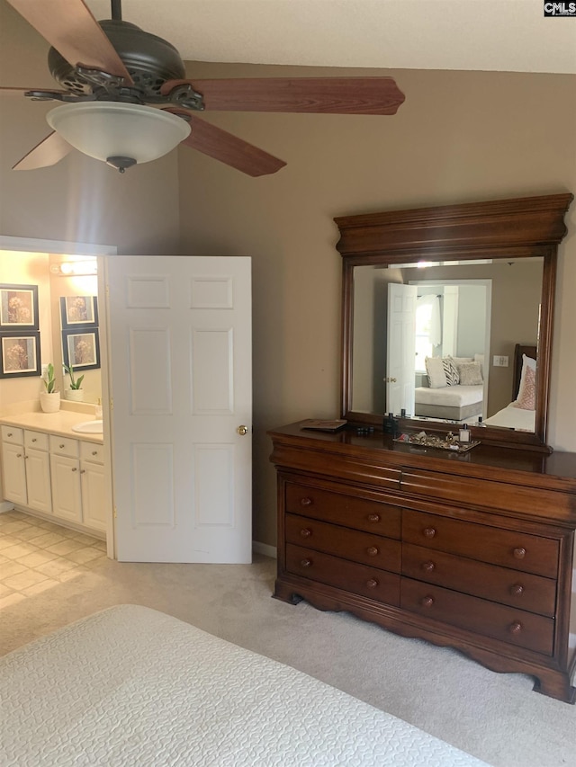 bedroom with light carpet, ensuite bathroom, and ceiling fan