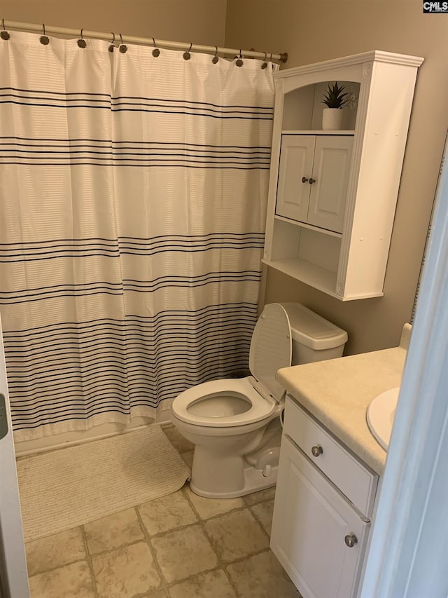 bathroom with toilet, vanity, and a shower with shower curtain