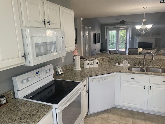 kitchen with stone countertops, a sink, white appliances, pendant lighting, and white cabinetry