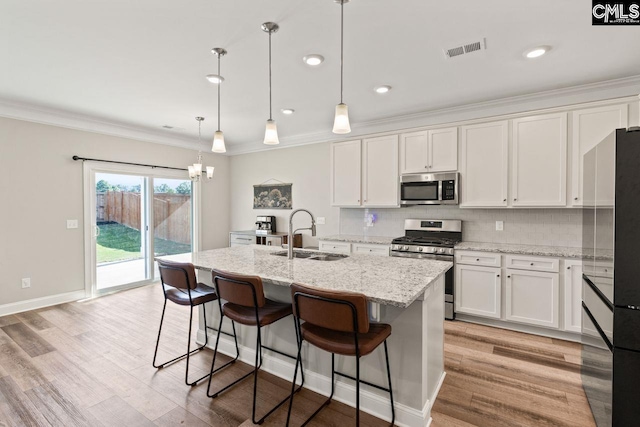 kitchen featuring white cabinets, visible vents, appliances with stainless steel finishes, and a sink