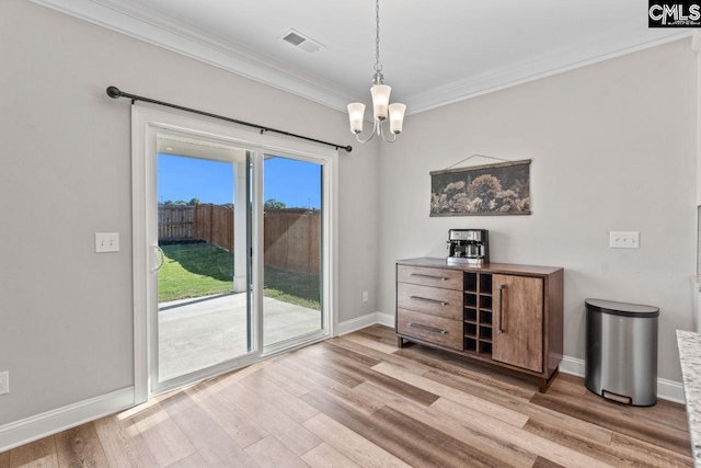 dining room with light wood finished floors, visible vents, crown molding, baseboards, and a chandelier
