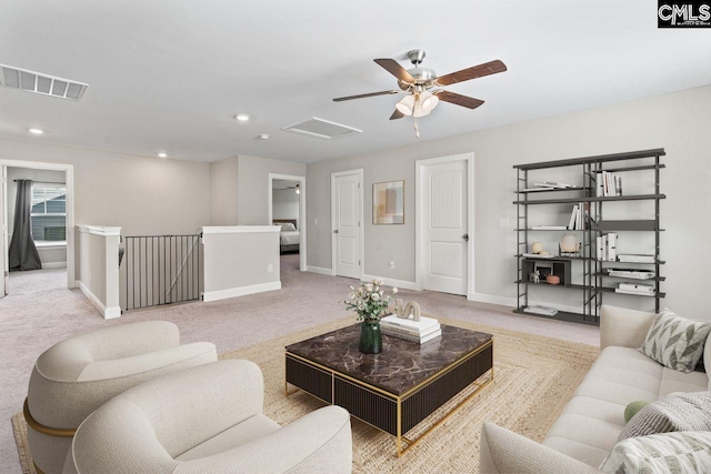 living area featuring attic access, visible vents, baseboards, and light carpet