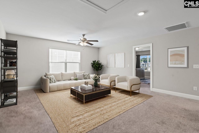 living area with carpet floors, visible vents, baseboards, and ceiling fan