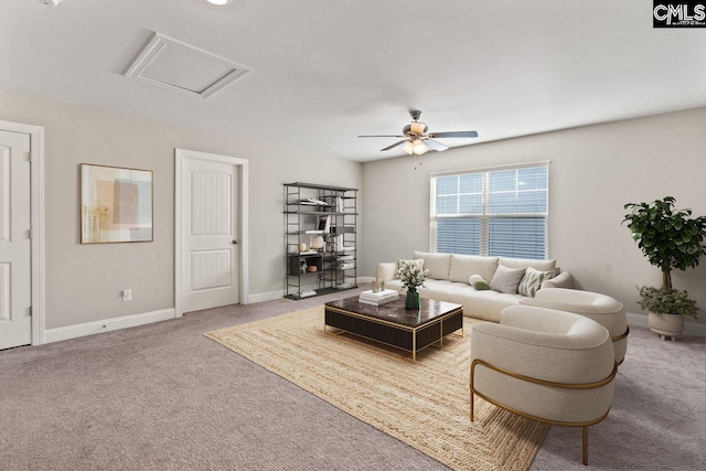 living room with attic access, baseboards, carpet flooring, and ceiling fan