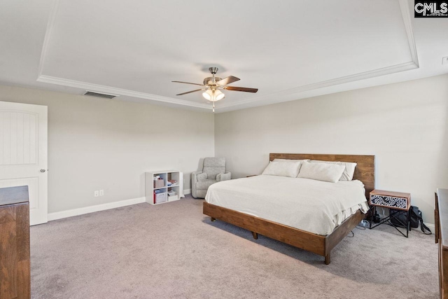 carpeted bedroom featuring a tray ceiling, visible vents, baseboards, and ceiling fan