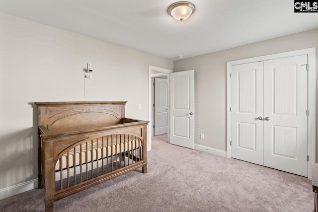 bedroom with baseboards, carpet floors, and a closet
