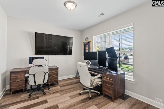 home office with baseboards, wood finished floors, and visible vents