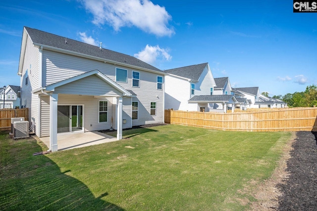 rear view of property with a yard, central AC unit, a patio, and fence