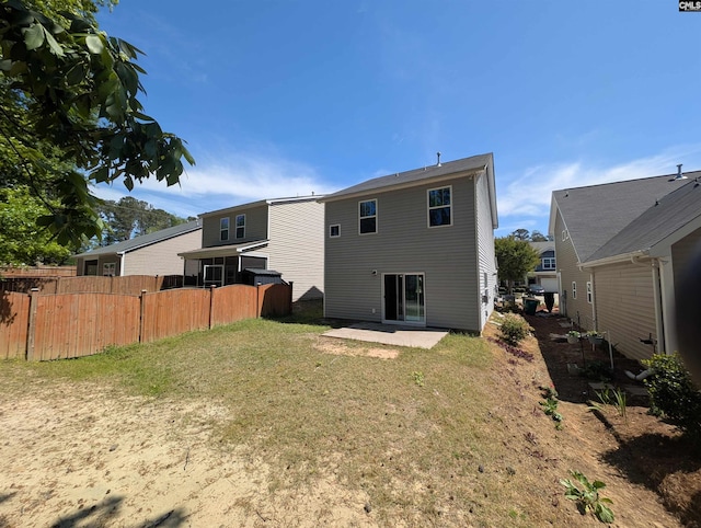 rear view of house with fence, a yard, and a patio