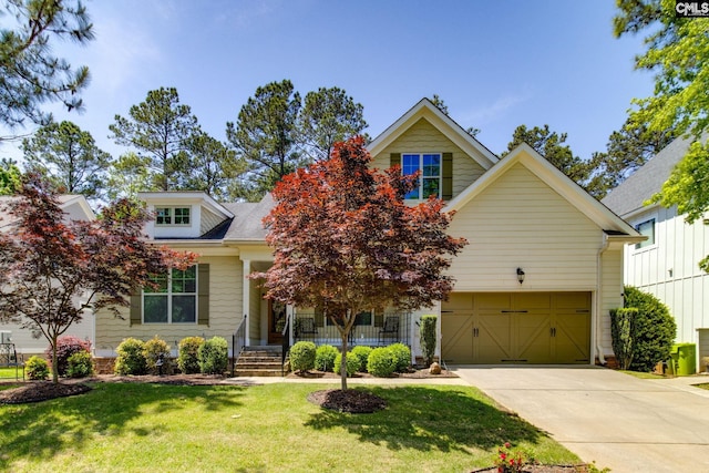 view of front of property featuring a garage, driveway, a front lawn, and covered porch
