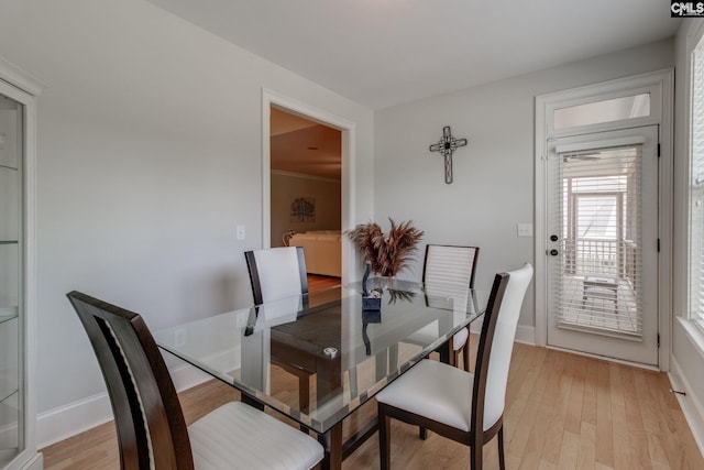 dining space featuring baseboards and light wood-style floors