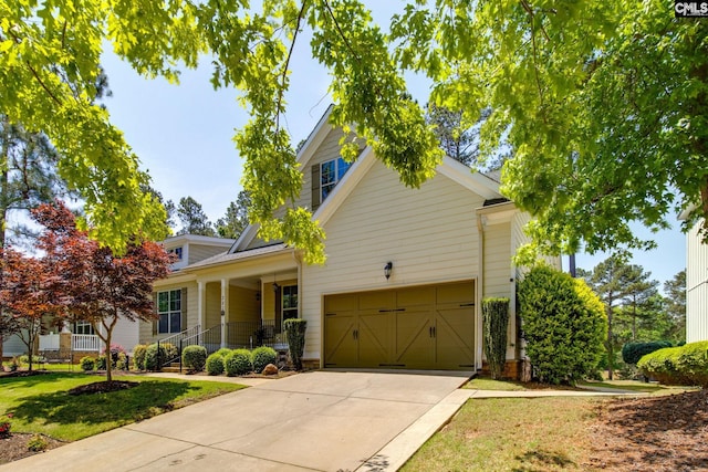 view of front of property featuring a porch, a front lawn, a garage, and concrete driveway