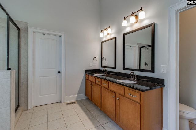 bathroom with tile patterned floors, a sink, a shower stall, and double vanity