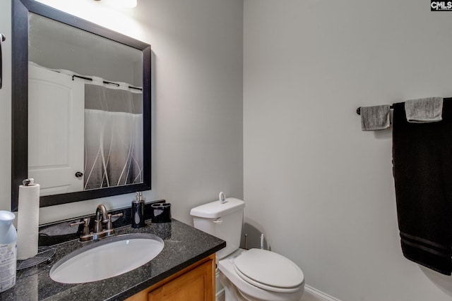 full bathroom featuring toilet, vanity, and a shower with shower curtain