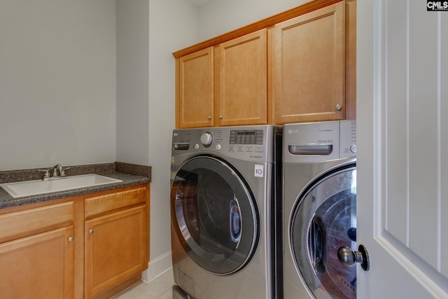clothes washing area featuring separate washer and dryer, a sink, and cabinet space
