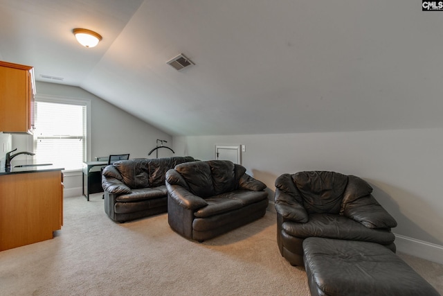 living area featuring baseboards, lofted ceiling, visible vents, and light colored carpet