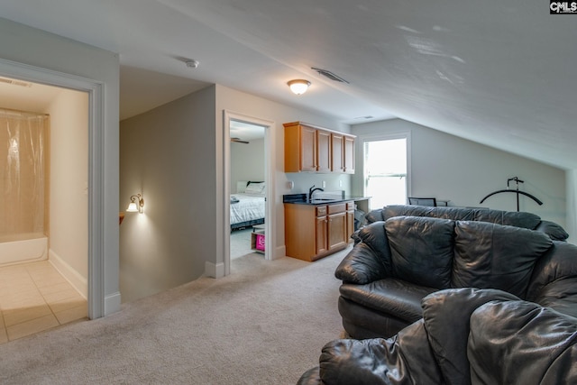 living area featuring vaulted ceiling, visible vents, and light carpet