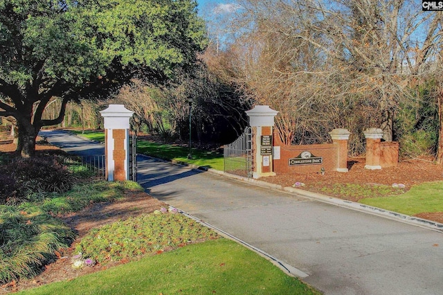view of road featuring curbs and a gate
