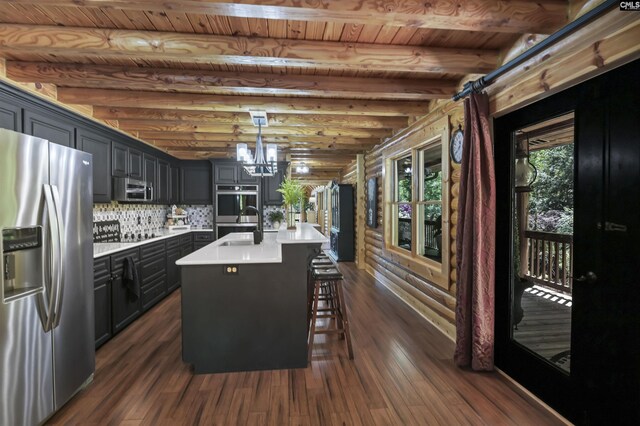 kitchen with dark wood-style floors, light countertops, a sink, a chandelier, and appliances with stainless steel finishes