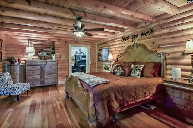bedroom featuring beam ceiling, log walls, hardwood / wood-style flooring, and wooden ceiling