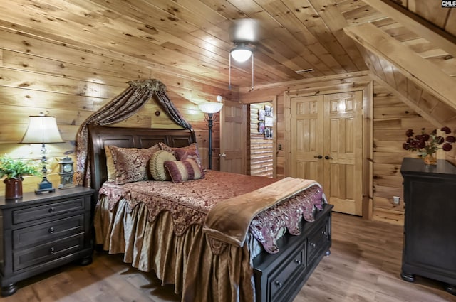 bedroom with wooden walls, wood finished floors, and wooden ceiling
