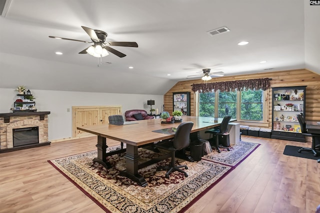 dining room featuring vaulted ceiling, a ceiling fan, wood finished floors, and visible vents