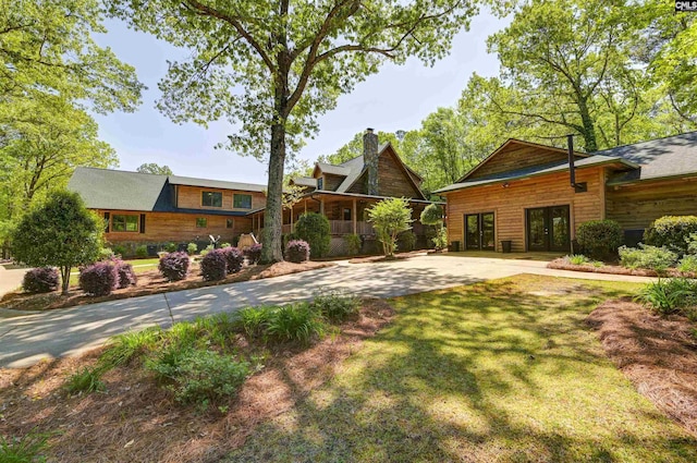 exterior space featuring a chimney, a lawn, and french doors