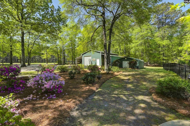 view of yard with fence, an outbuilding, and a garage