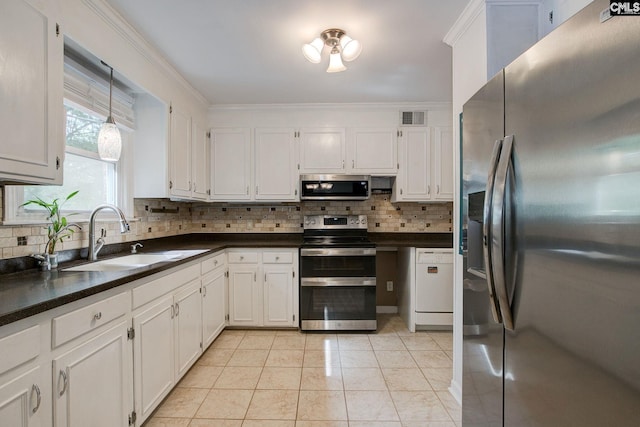 kitchen featuring a sink, dark countertops, visible vents, crown molding, and appliances with stainless steel finishes