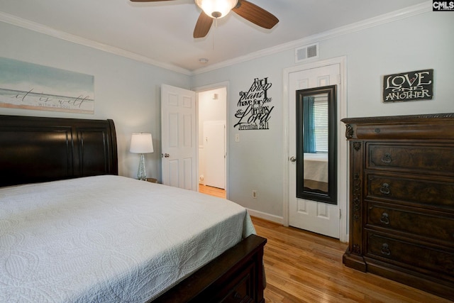 bedroom featuring baseboards, visible vents, a ceiling fan, wood finished floors, and crown molding