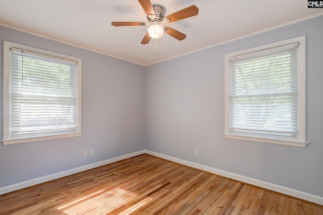 empty room featuring ceiling fan, baseboards, crown molding, and light wood-style flooring