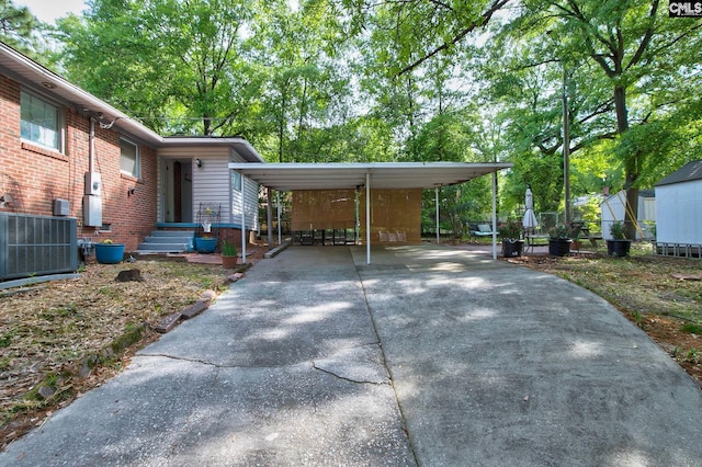 exterior space featuring a detached carport, driveway, and central AC unit