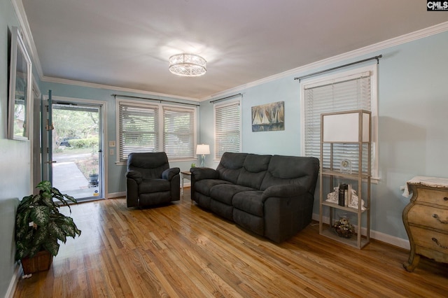 living area featuring a chandelier, wood finished floors, crown molding, and baseboards