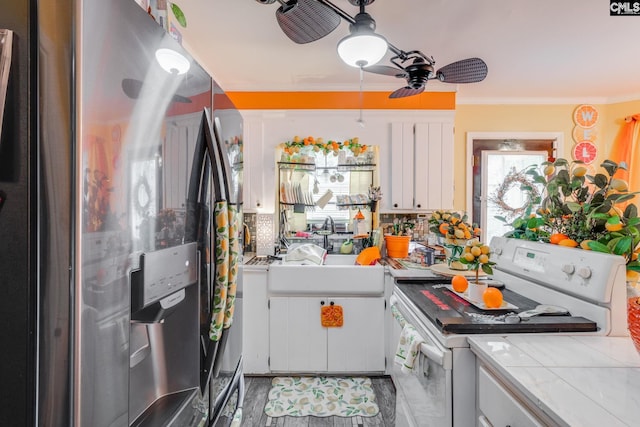 kitchen featuring stainless steel fridge, white stove, a ceiling fan, white cabinets, and ornamental molding
